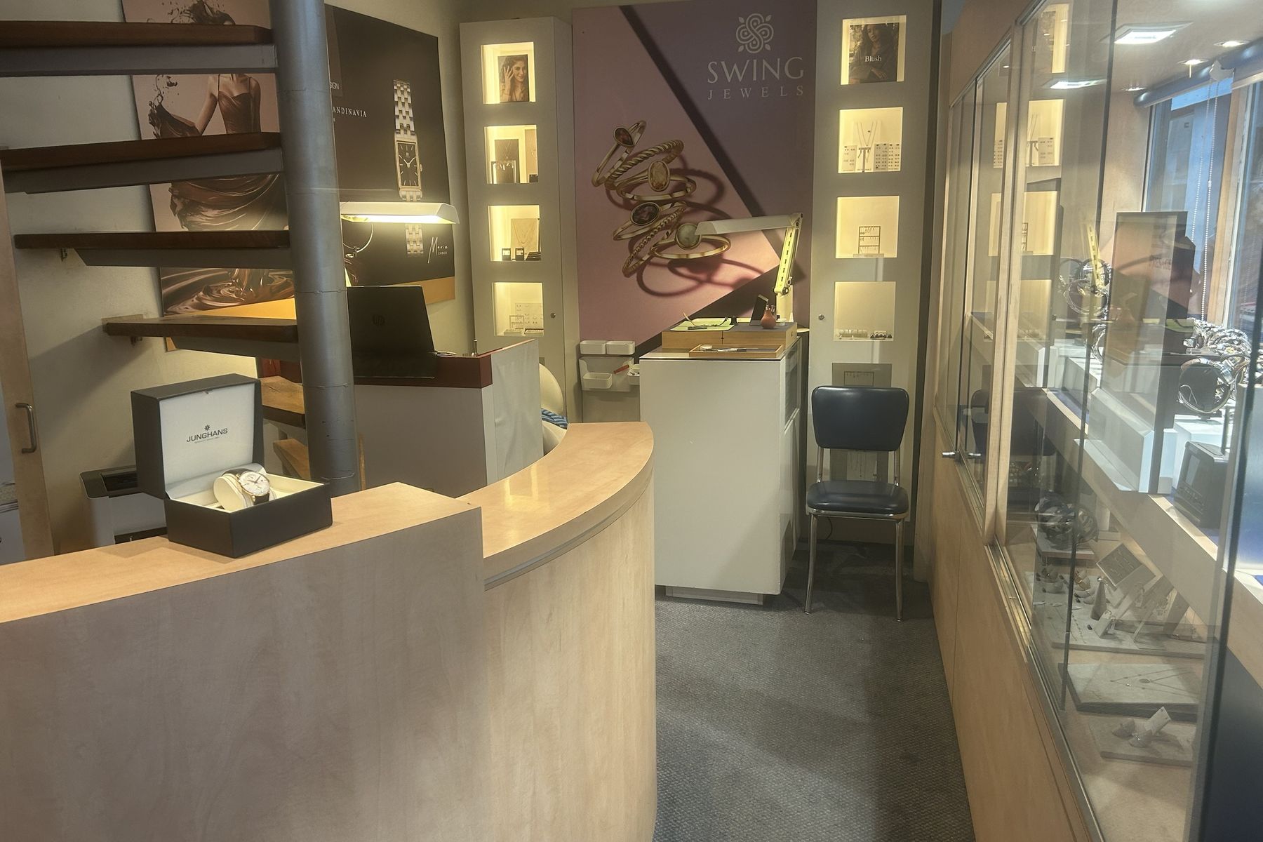 De toonbank van Top Time, met een Junghans-horloge in zijn doos en de wenteltrap erachter